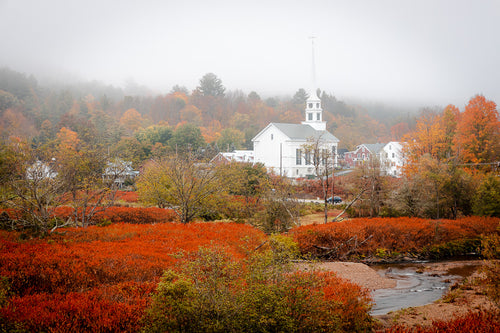 A view of Downtown Stowe, Vermont and the Little River during peak foliage